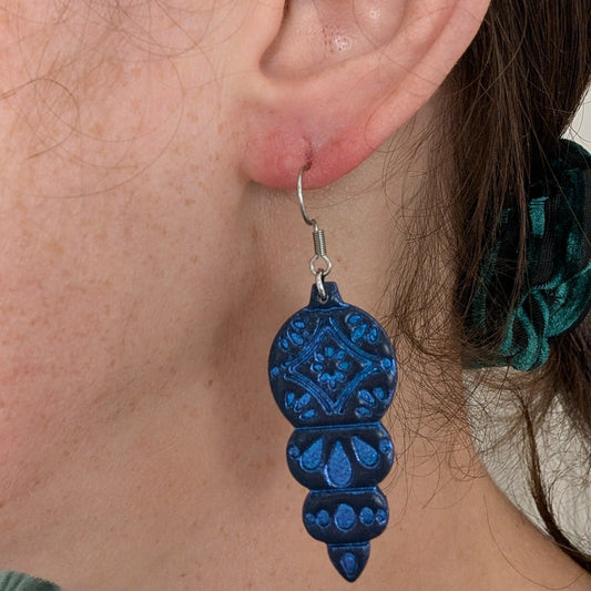 Blue Christmas ornament dangle earring shown on ear for 4.5 cm scale