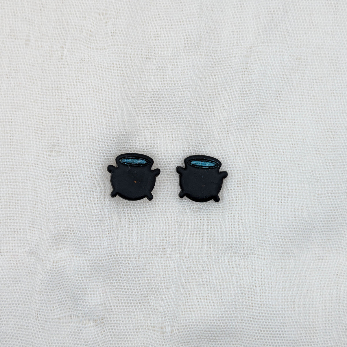 Black witch cauldron stud earrings with blue potion rims
