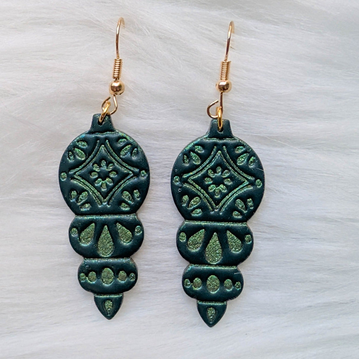 Green ornament dangle earrings with embossed details and gold-plated stainless steel hooks
