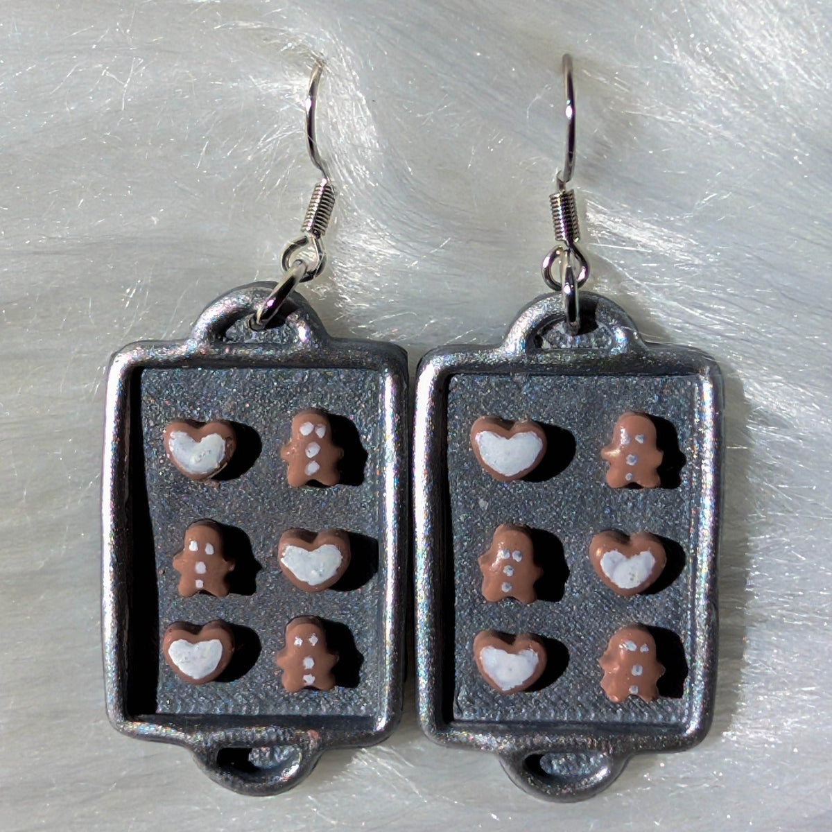 Pair of silver baking sheet earrings decorated with tiny gingerbread and heart cookies