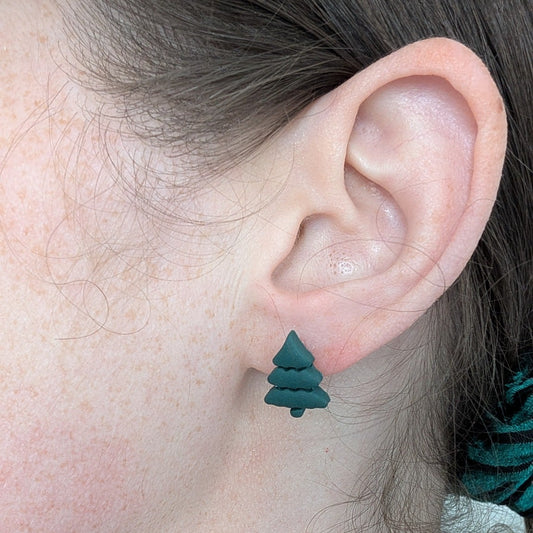 Mini green Christmas tree stud earring shown on ear for scale