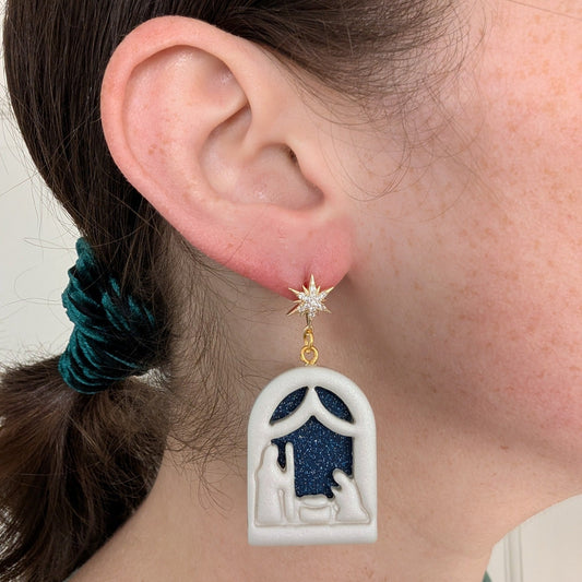 Gold North Star nativity dangle earring shown on ear for 4 cm scale