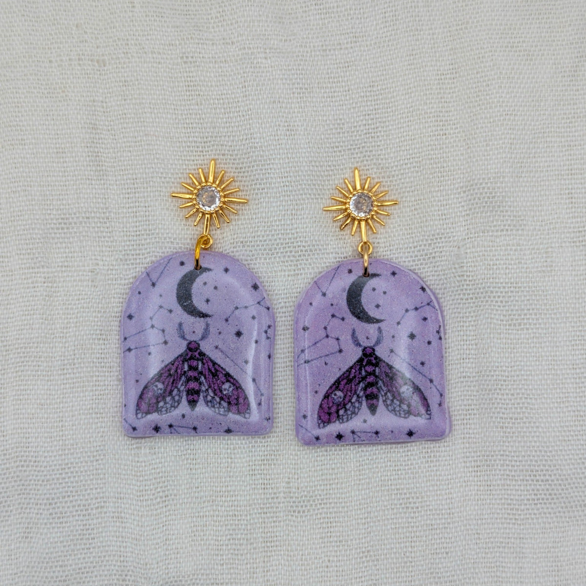 Purple moth arch earrings with gold cubic zirconia starburst posts and celestial pattern