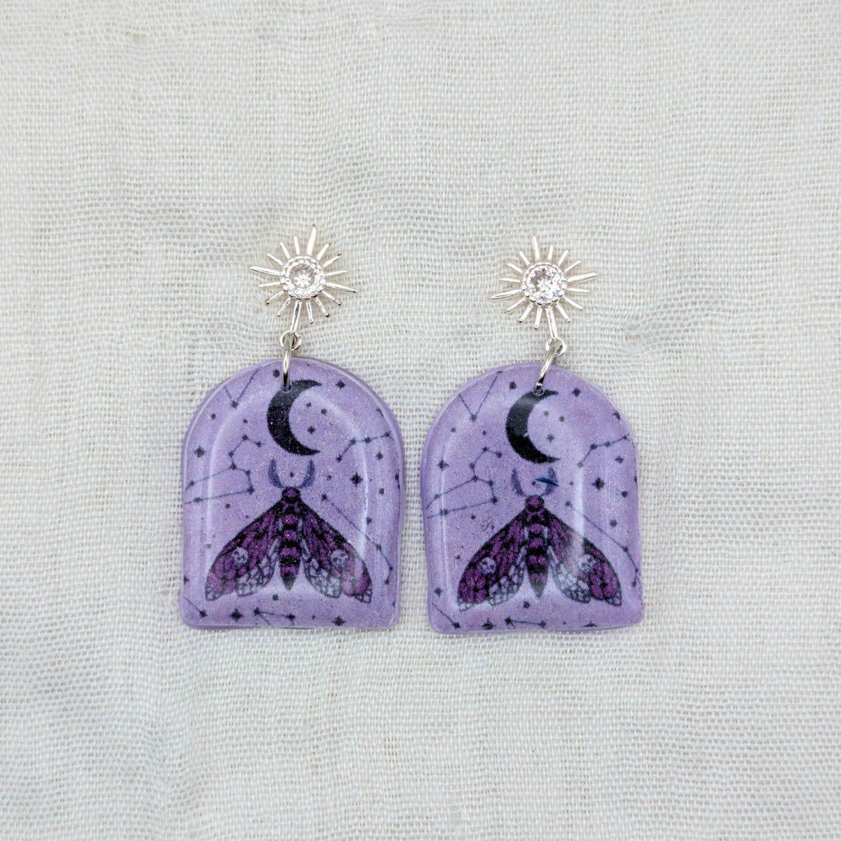 Purple moth arch earrings with silver cubic zirconia starburst posts and celestial pattern