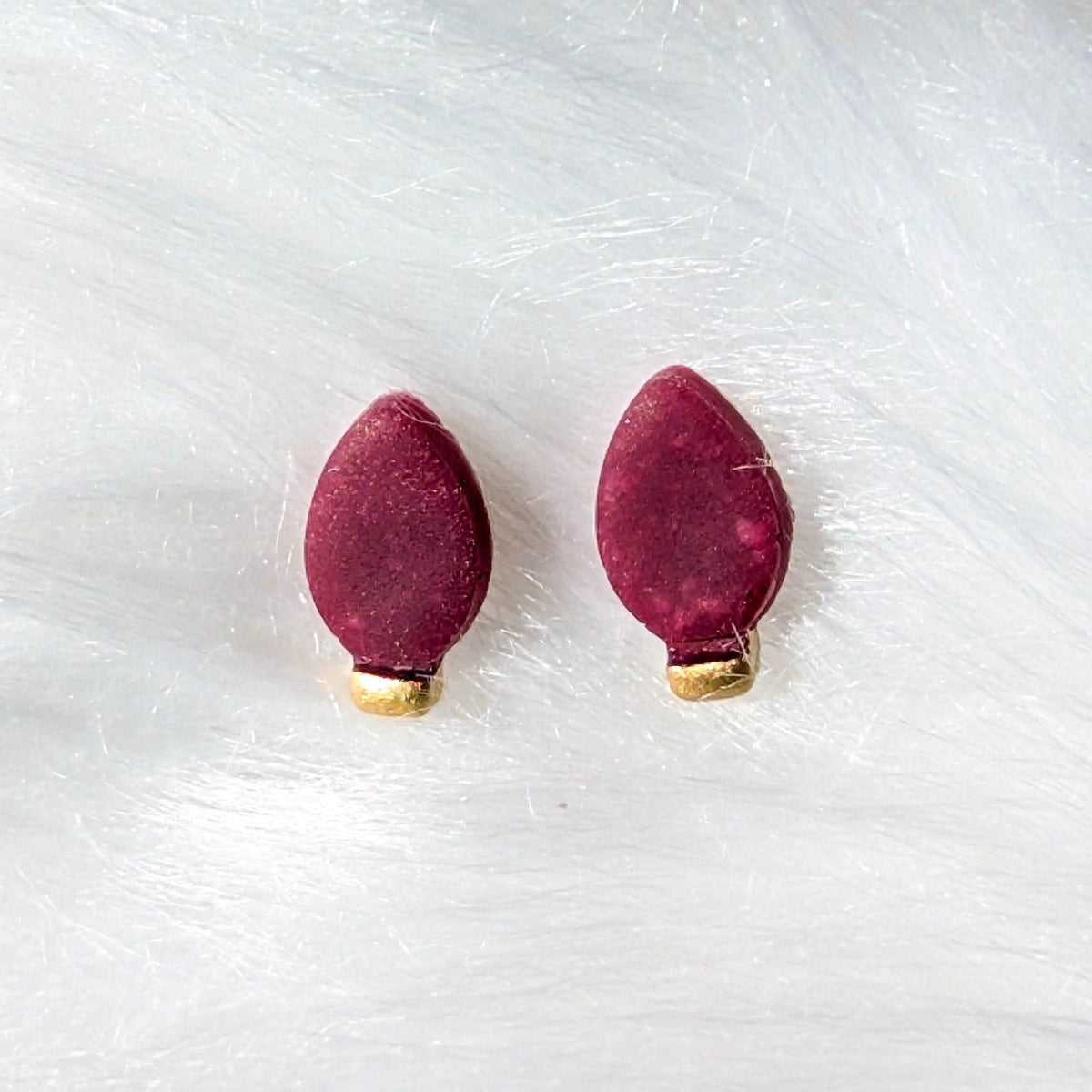 Red Christmas light bulb stud earrings with a gold metallic finish