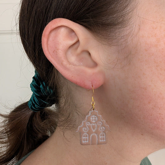 Romantic gingerbread house dangle earring with gold-tone hook shown on ear