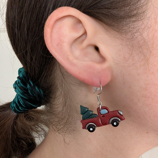 Red vintage Christmas tree truck dangle earring shown on ear for scale