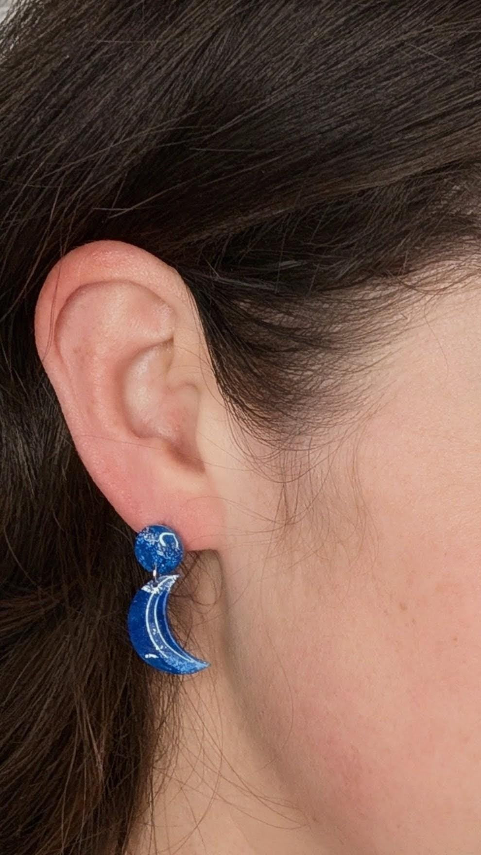 Close-up of a woman wearing blue earrings.