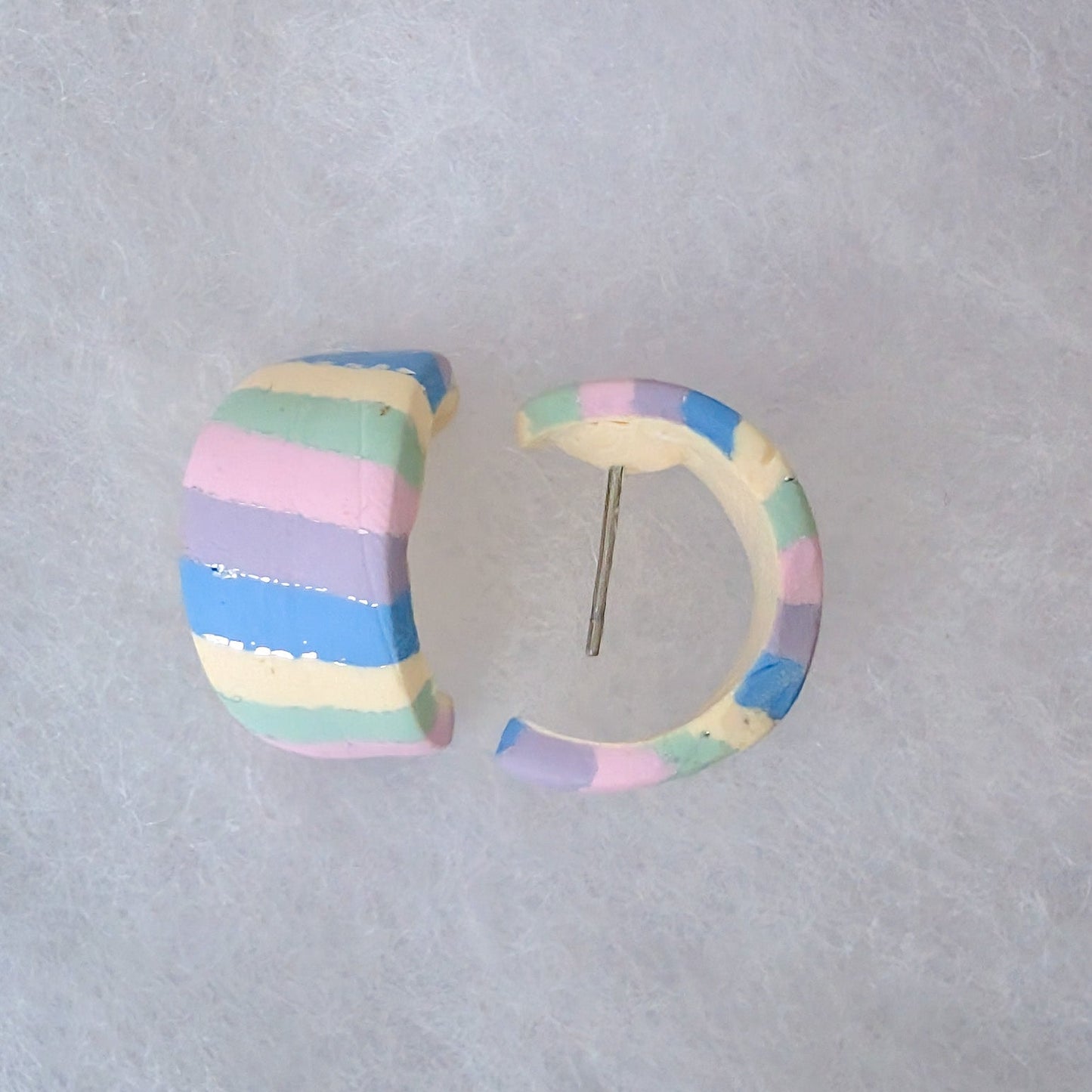A pair of handmade pastel striped hoop earrings with a silver metal postt