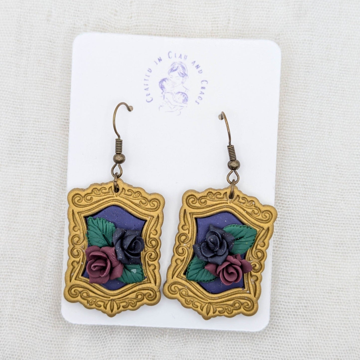 Antique gold vintage frame earrings with purple background, sculpted burgundy and dark purple roses, and bronze-tone hooks