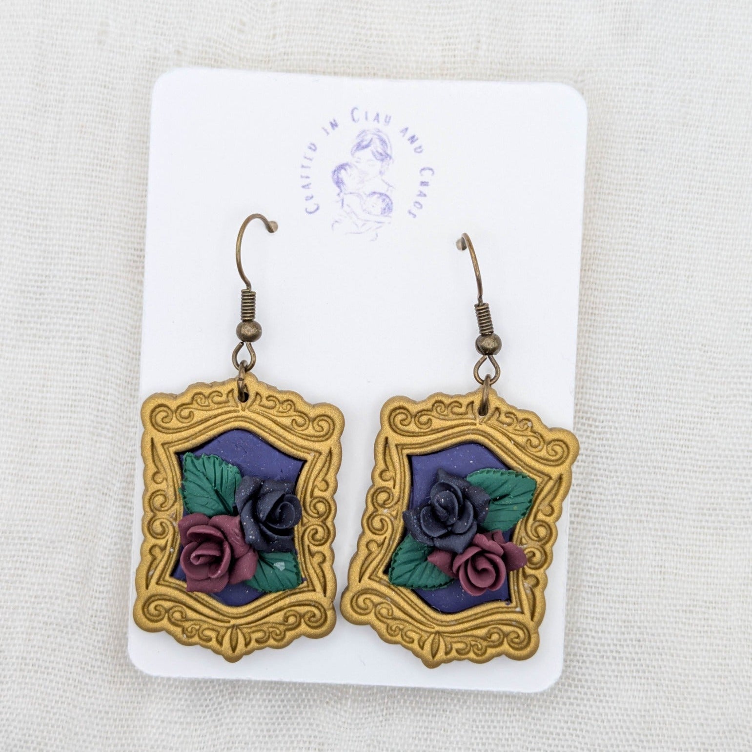 Antique gold vintage frame earrings with purple background, sculpted burgundy and dark purple roses, and bronze-tone hooks