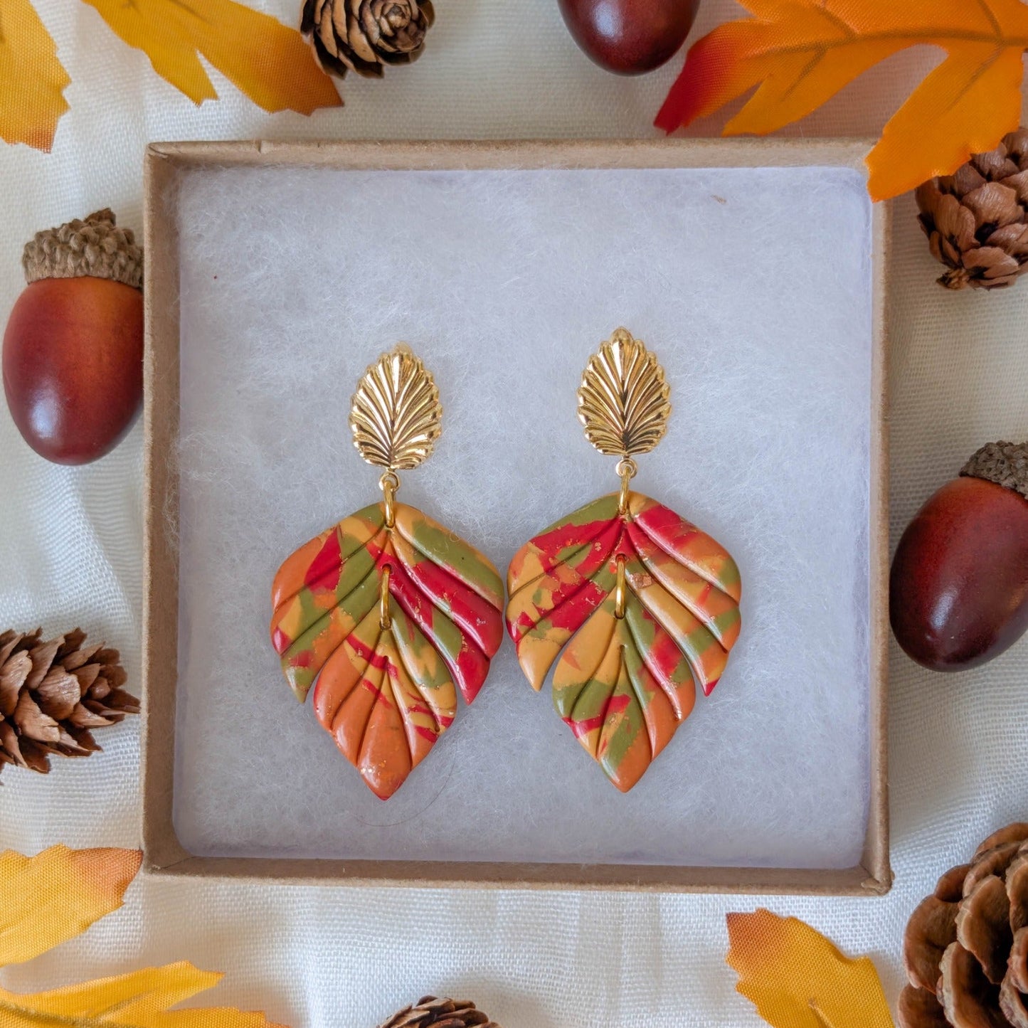 Handmade autumn marble leaf earrings in orange, mustard, red, and olive with gold leaf stud findings
