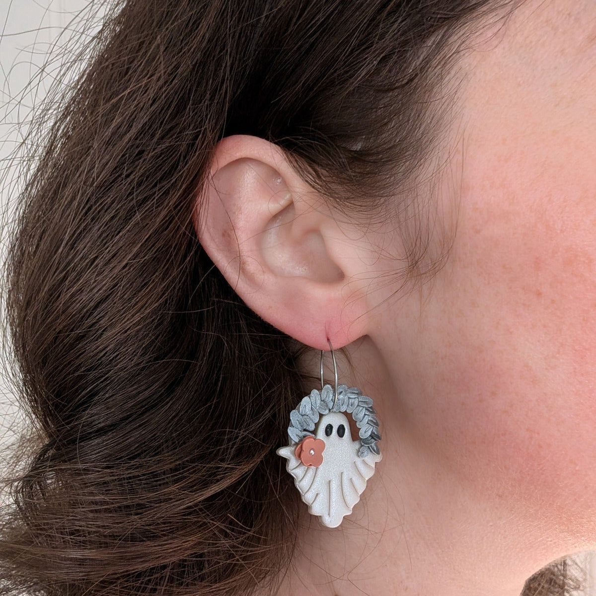 Botanical leaf ghost Halloween earring worn on ear, front view