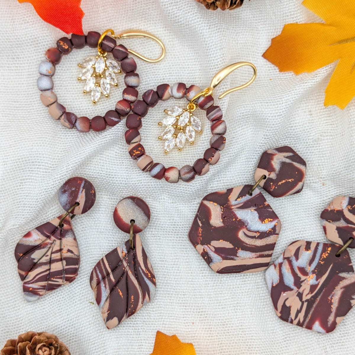 Neutral brown marble fall earrings in wreath, leaf and hexagon styles with copper accents