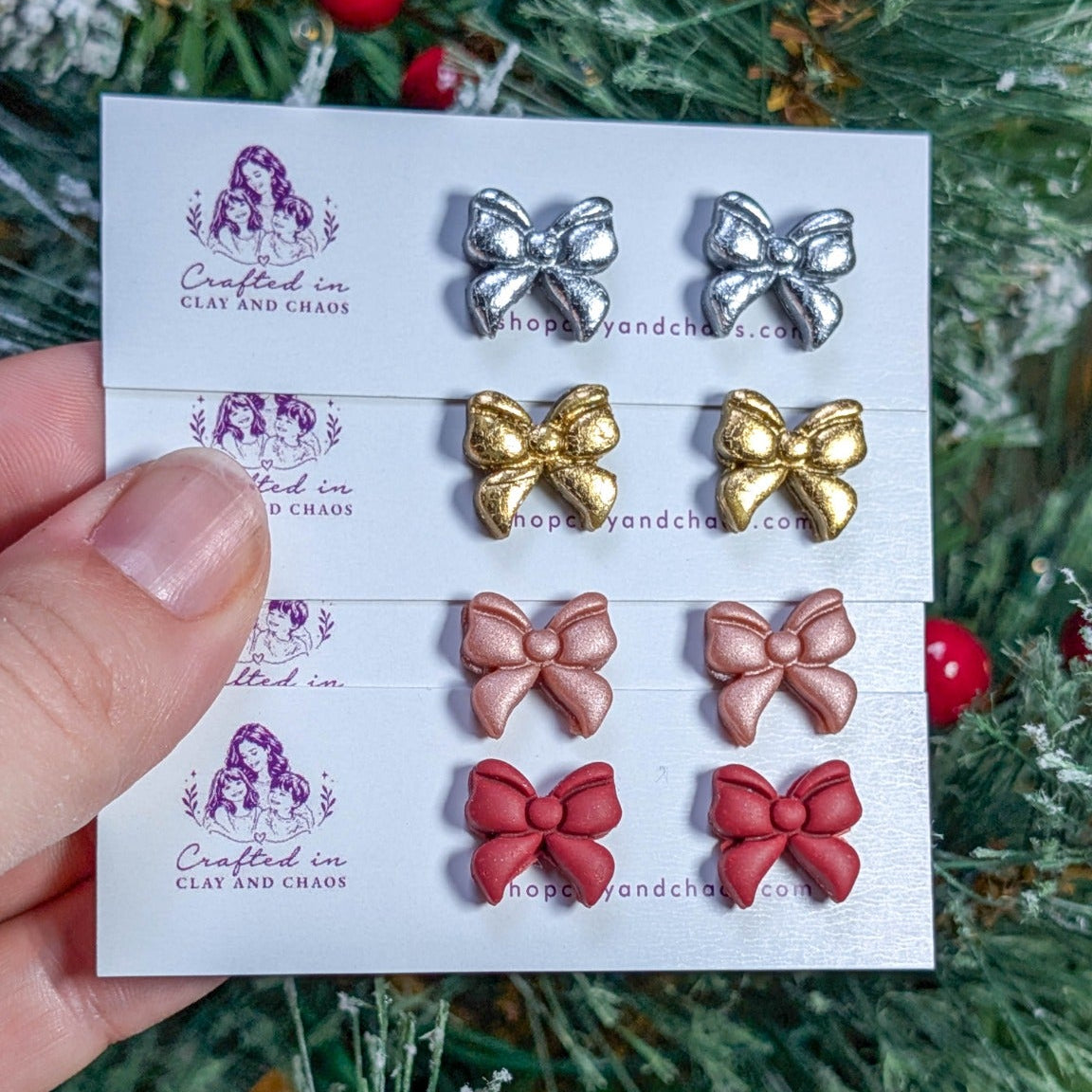 Red, rose gold, gold foil crackle and silver foil crackle bow stud earrings styled against a Christmas tree