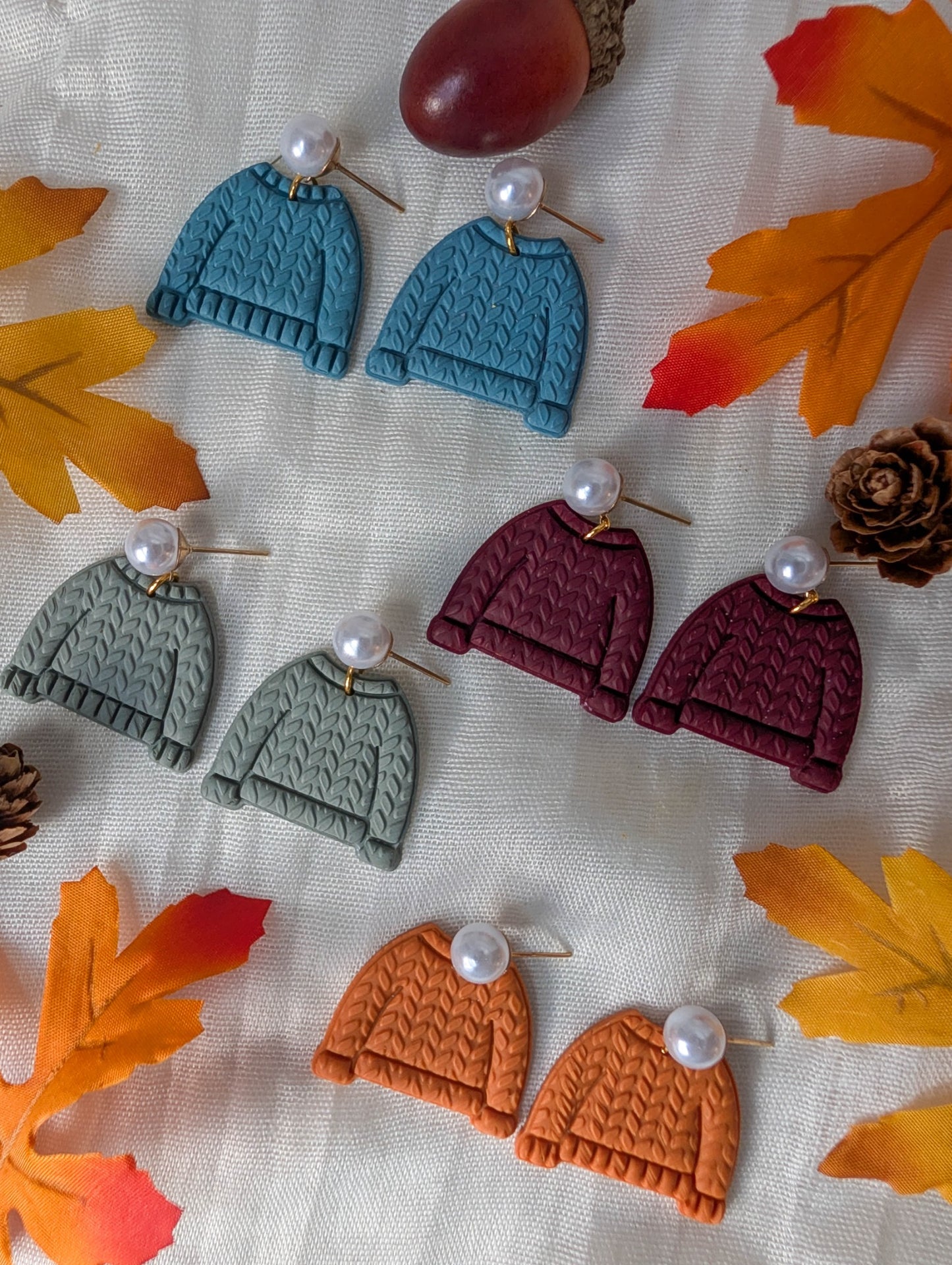 Cozy cable-knit sweater earrings in Vintage Blue, Sage Green, Crimson, and Burnt Orange with faux pearl posts