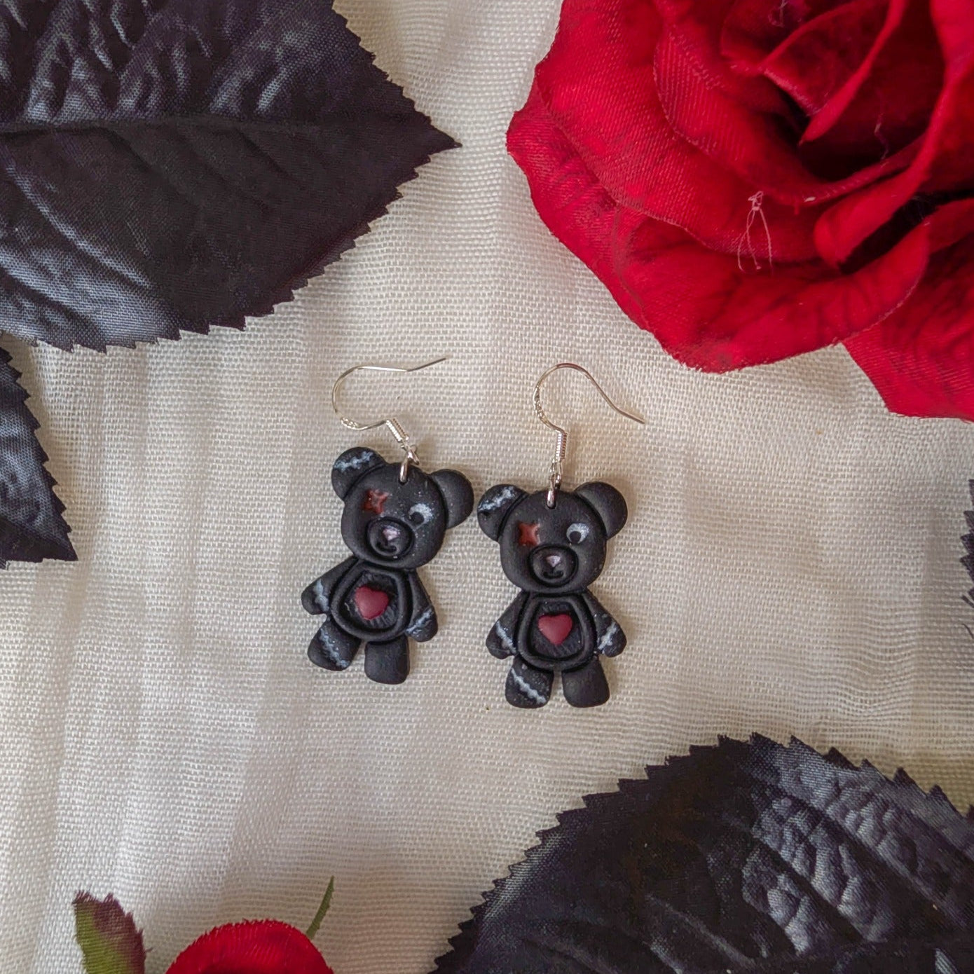 Deady Bear polymer clay Halloween earrings styled with red roses and black leaves