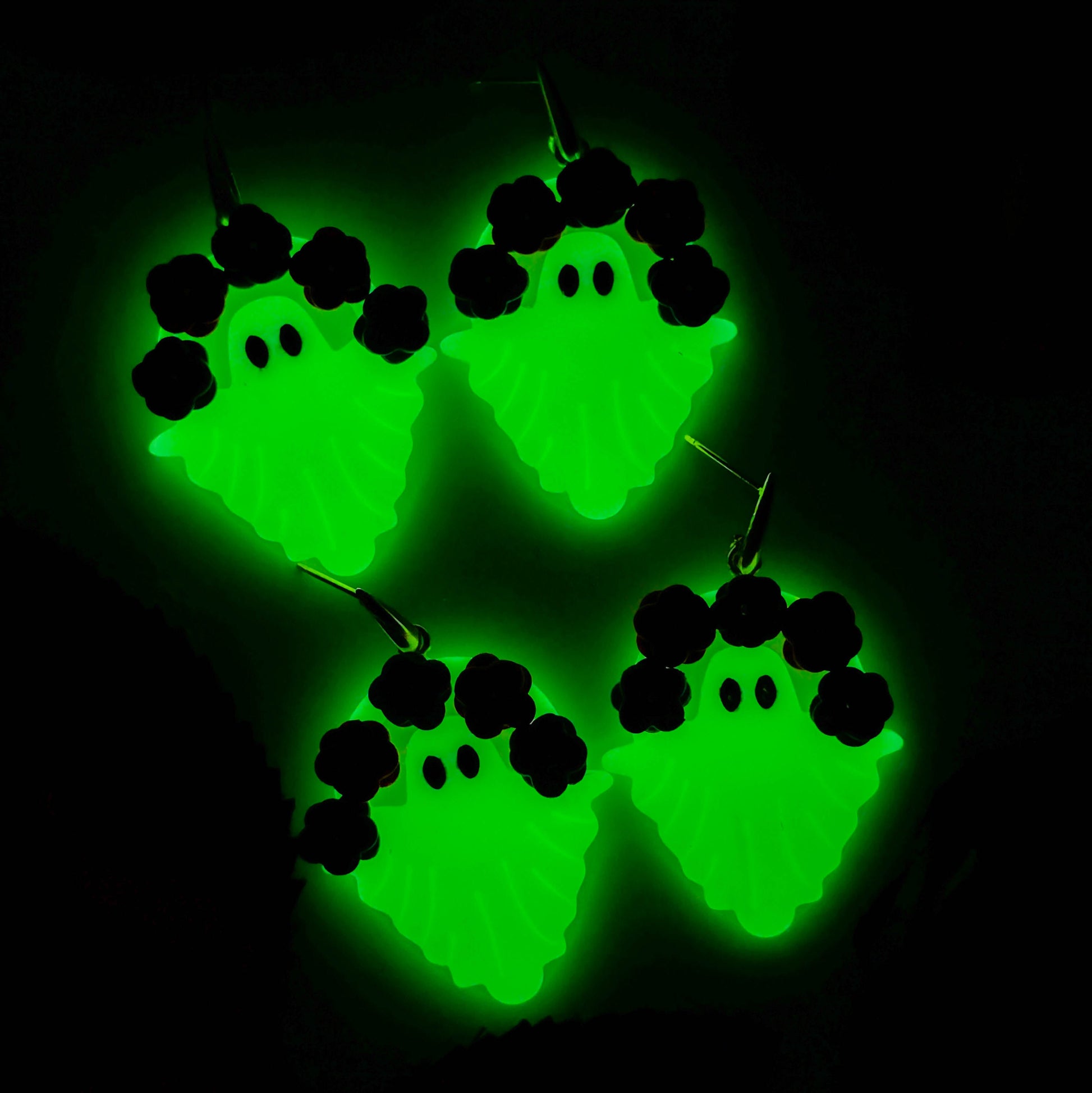 Glow-in-the-dark floral ghost earrings glowing bright green at night