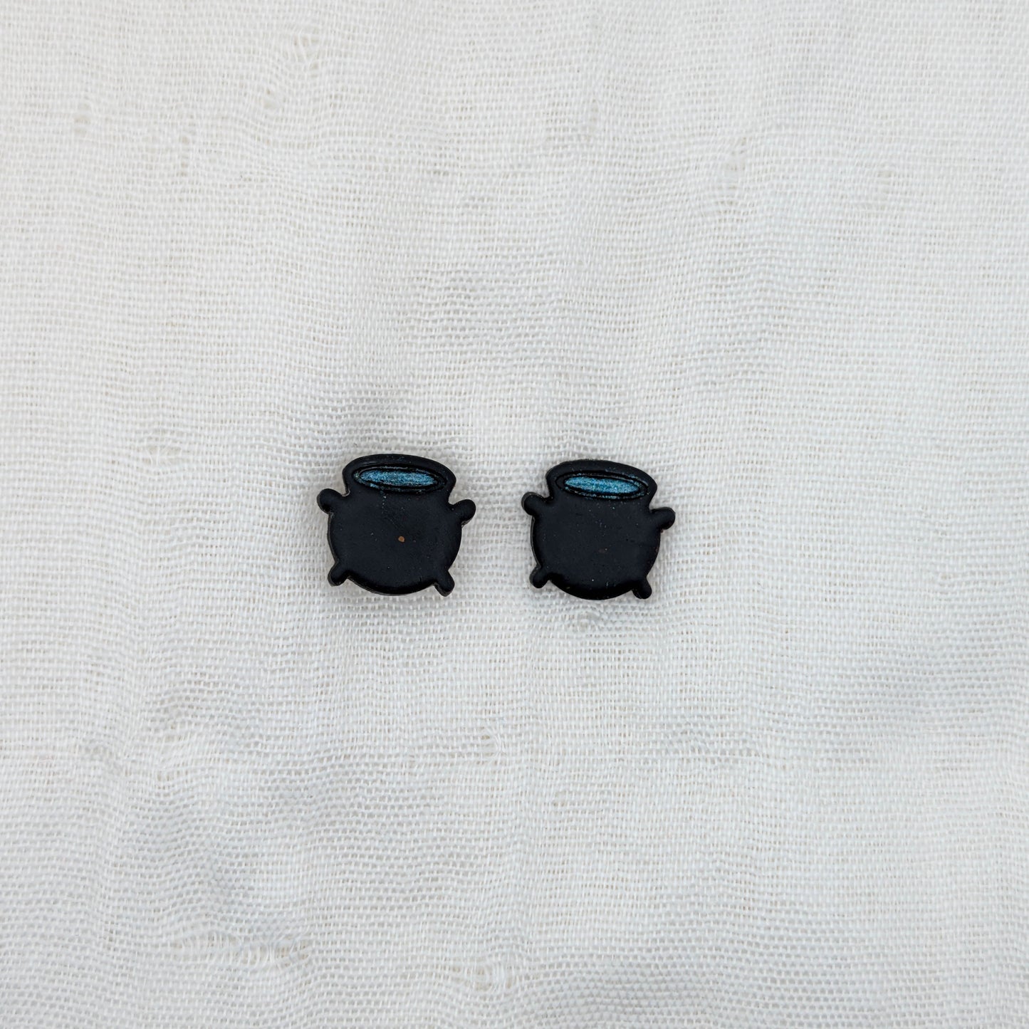 Black witch cauldron stud earrings with blue potion rims