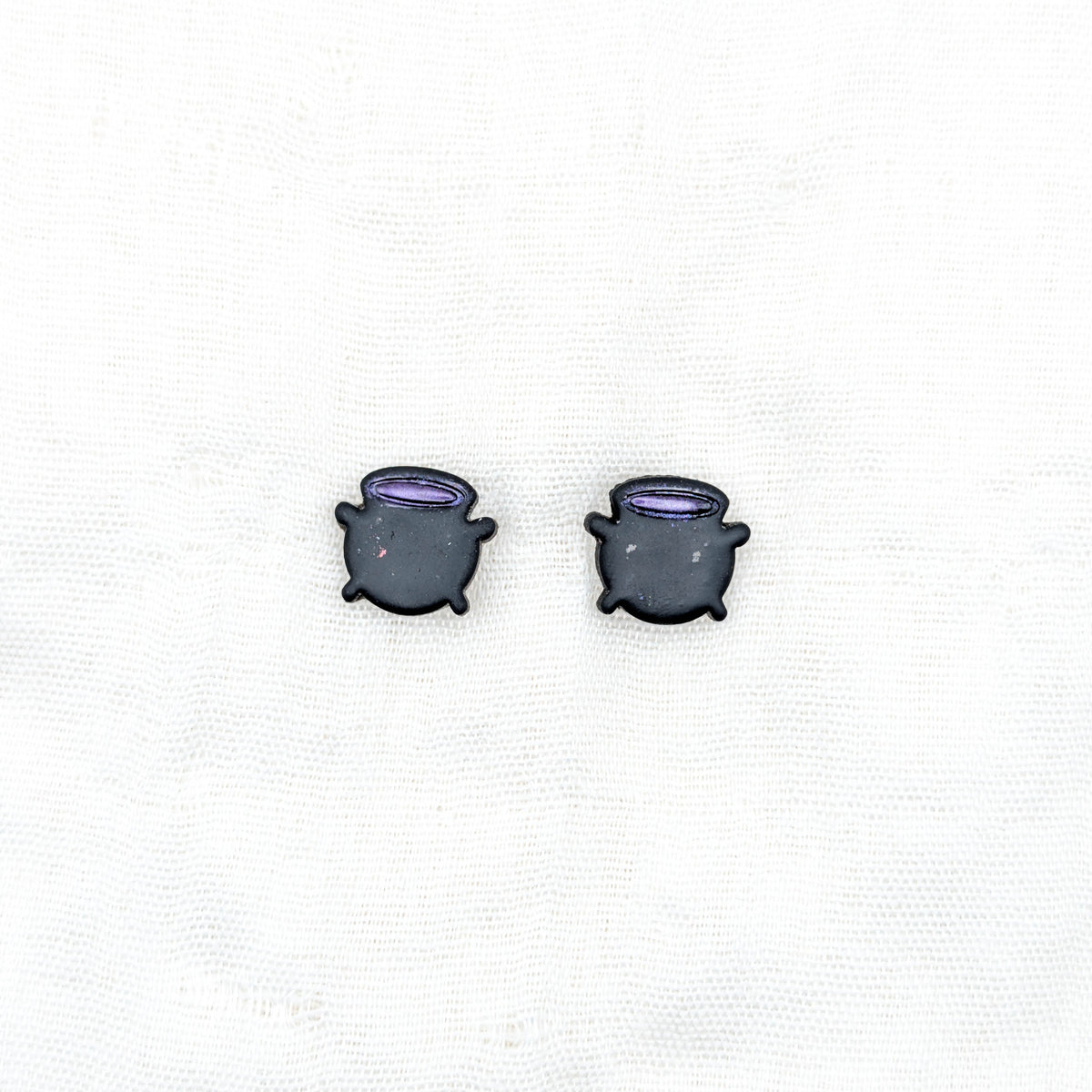 Black witch cauldron stud earrings with purple potion rims