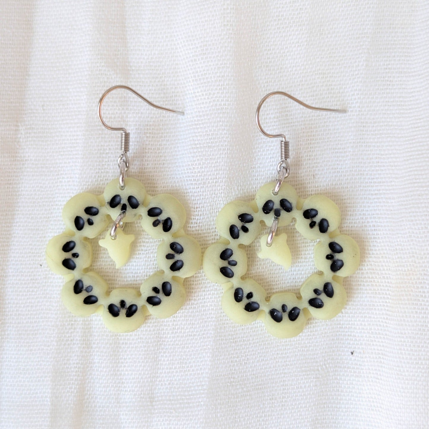 Pale green glow-in-the-dark skull wreath earrings with black details and dangling ghosts