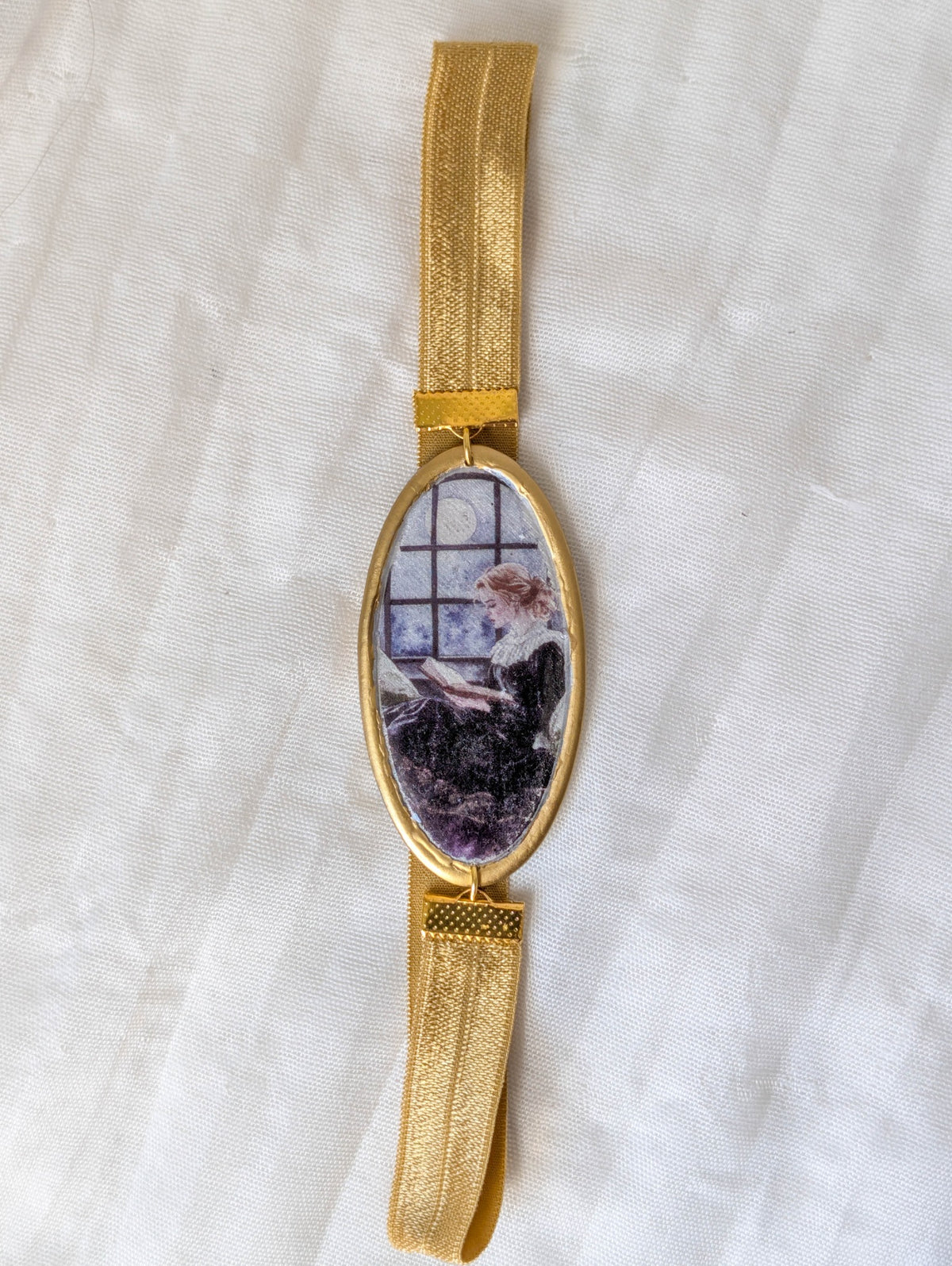 Full view of gold moonlit reader polymer clay bookmark with gold stretchy band