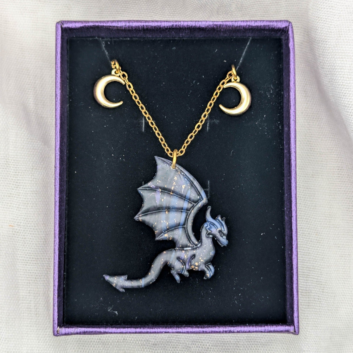 Side-profile marbled dragon necklace with gold chain and two crescent moon charms