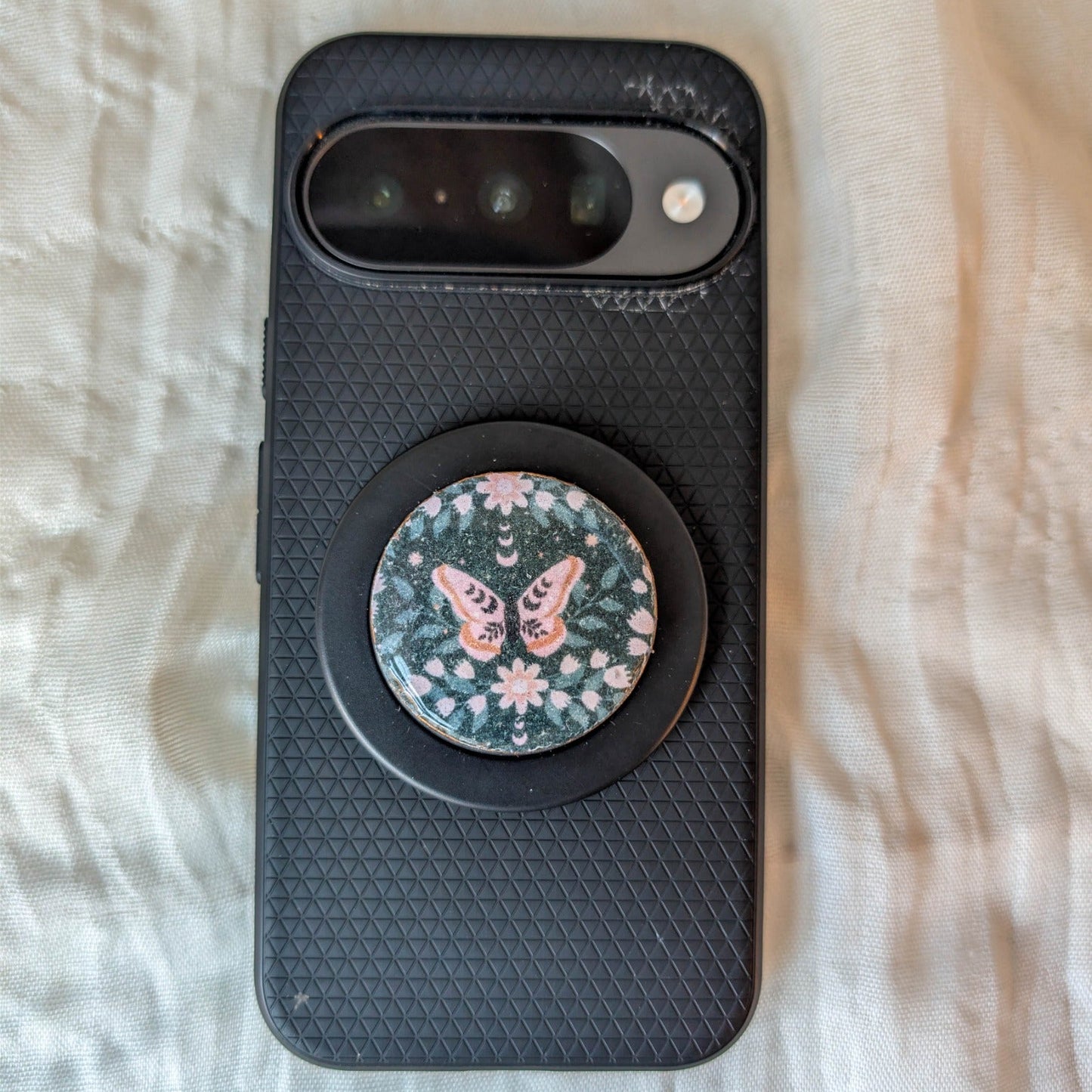 Witchy botanical moth MagSafe phone grip displayed on a black smartphone