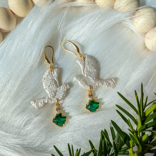 Green lace turtle dove earrings styled with winter greenery and gold-tone details