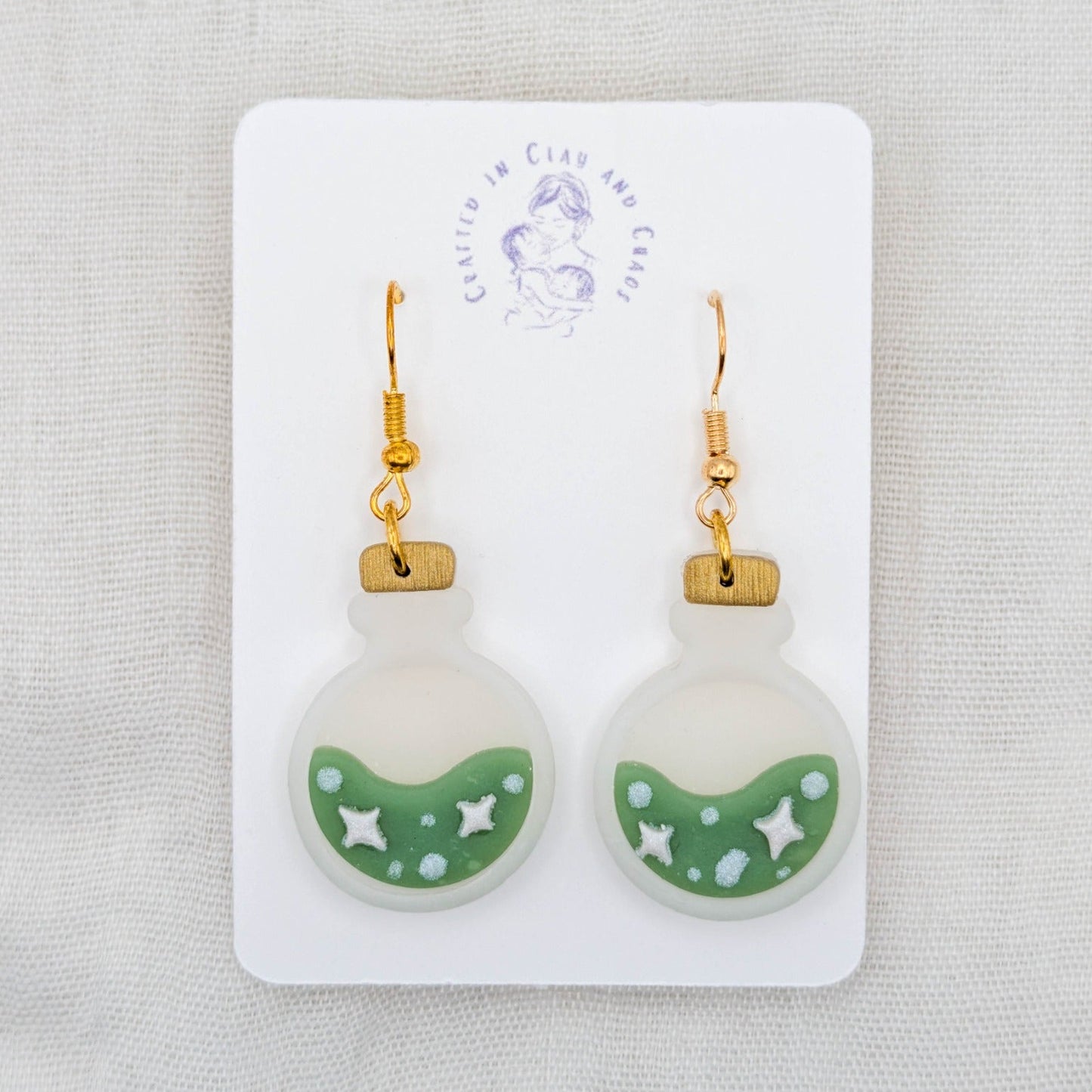 Green translucent potion bottle earrings with painted stars and bubbles on 18K gold-plated stainless steel hooks