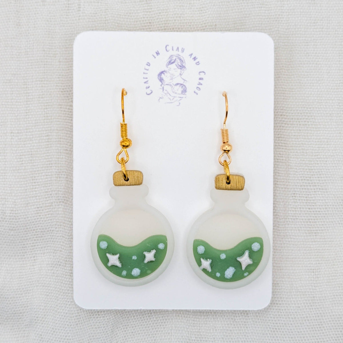 Green translucent potion bottle earrings with painted stars and bubbles on 18K gold-plated stainless steel hooks