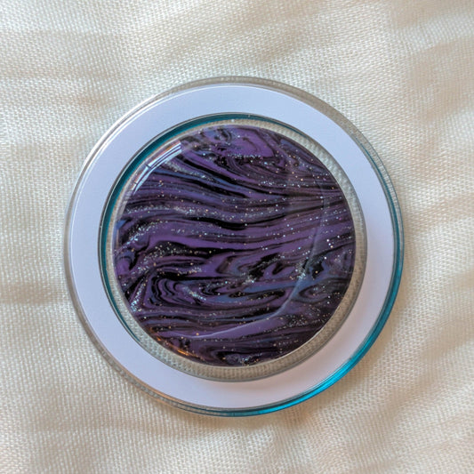 Close-up of clear MagSafe phone grip with purple black and blue handmade polymer clay marble under resin