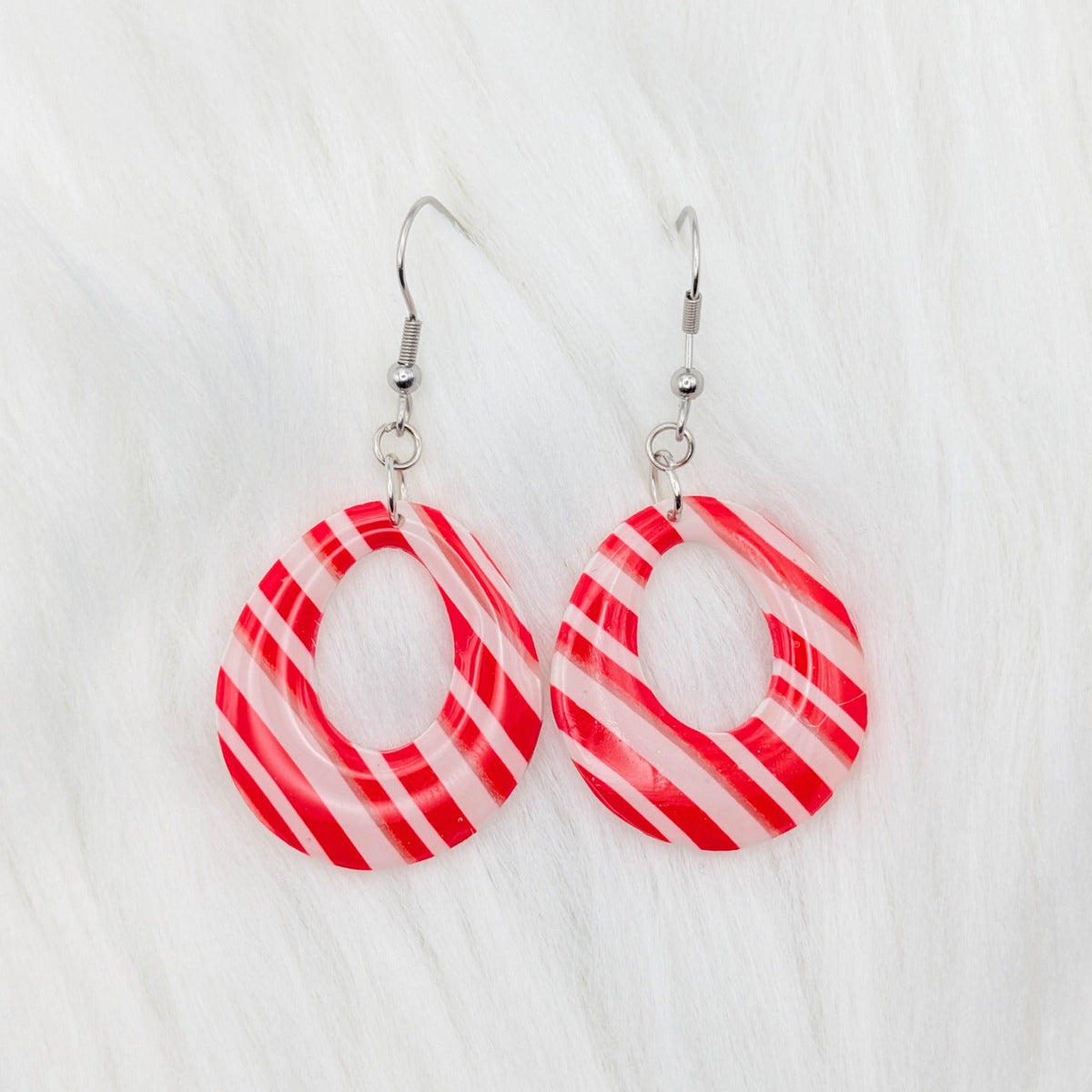 Open teardrop hoop earrings with red, white, and translucent candy cane stripes.