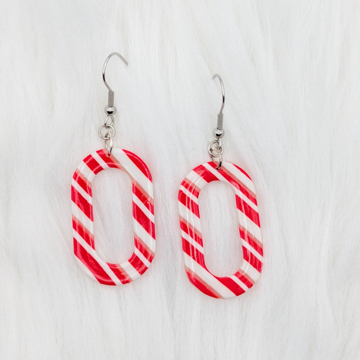 Slim rounded rectangle earrings with red, white, and translucent candy cane stripes.
