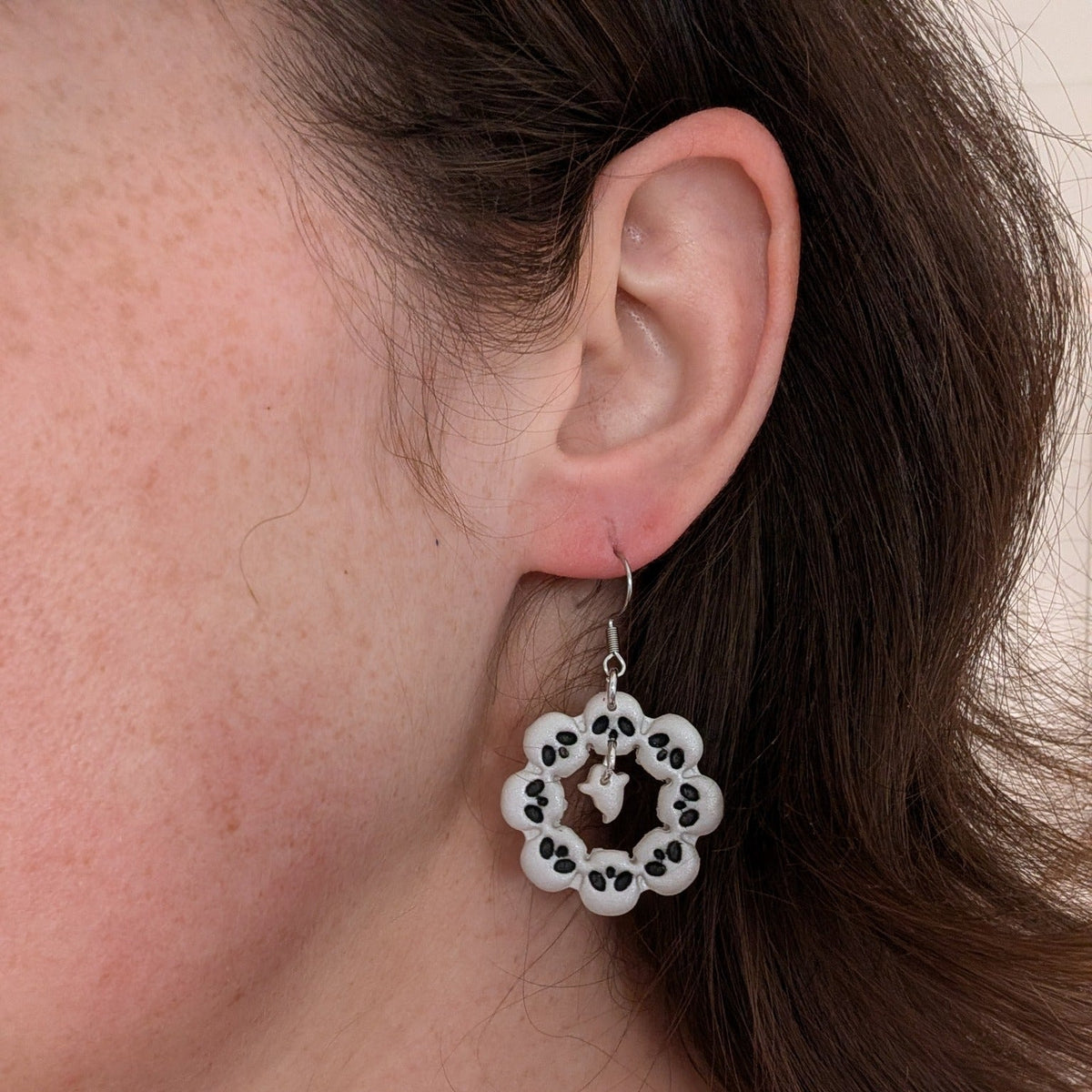 Pearlescent skull wreath Halloween earring with dangling ghost worn on ear