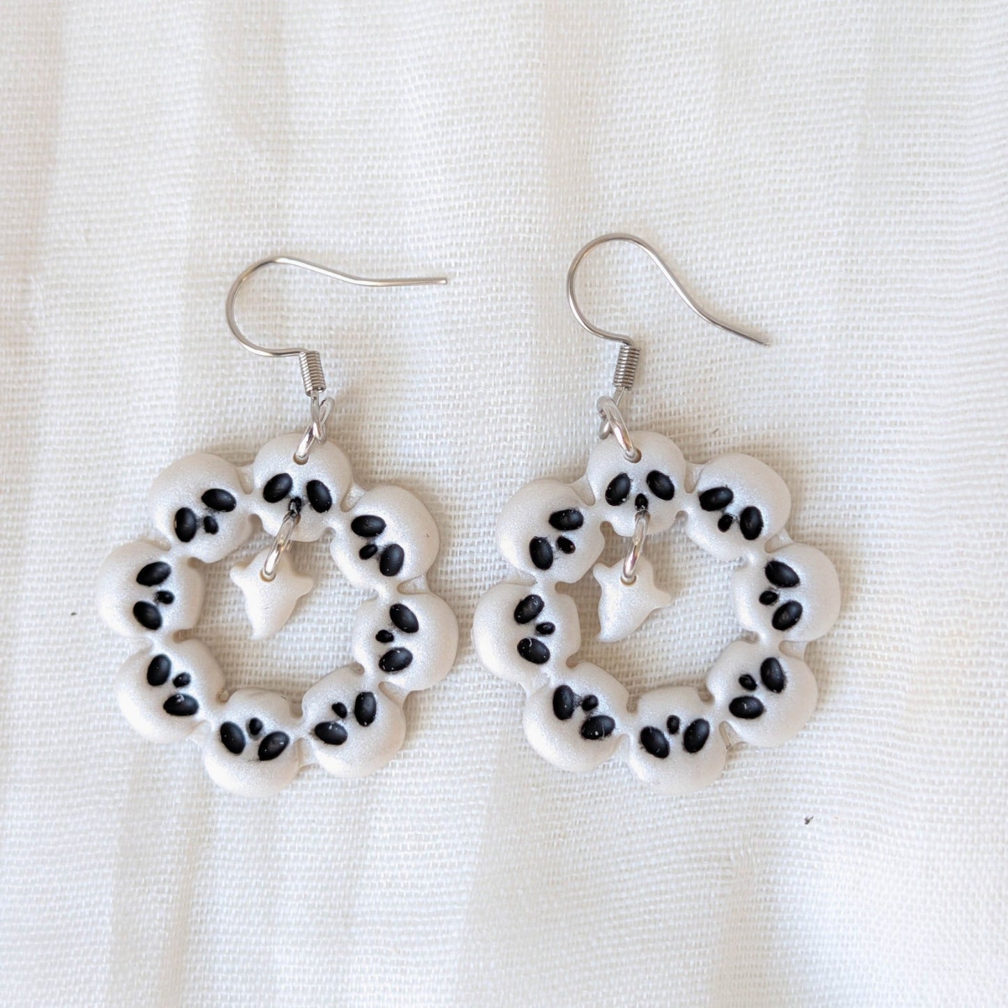 Pearlescent white skull wreath Halloween earrings with black details and dangling ghosts