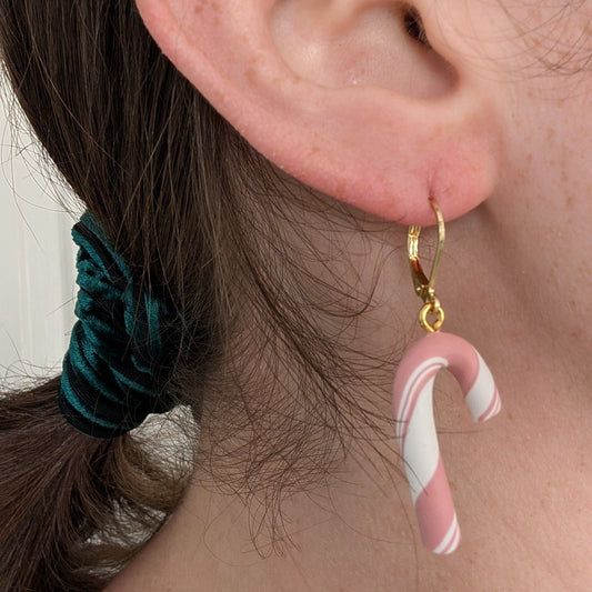 Pink and white candy cane dangle earring with gold-plated stainless steel finding worn on ear