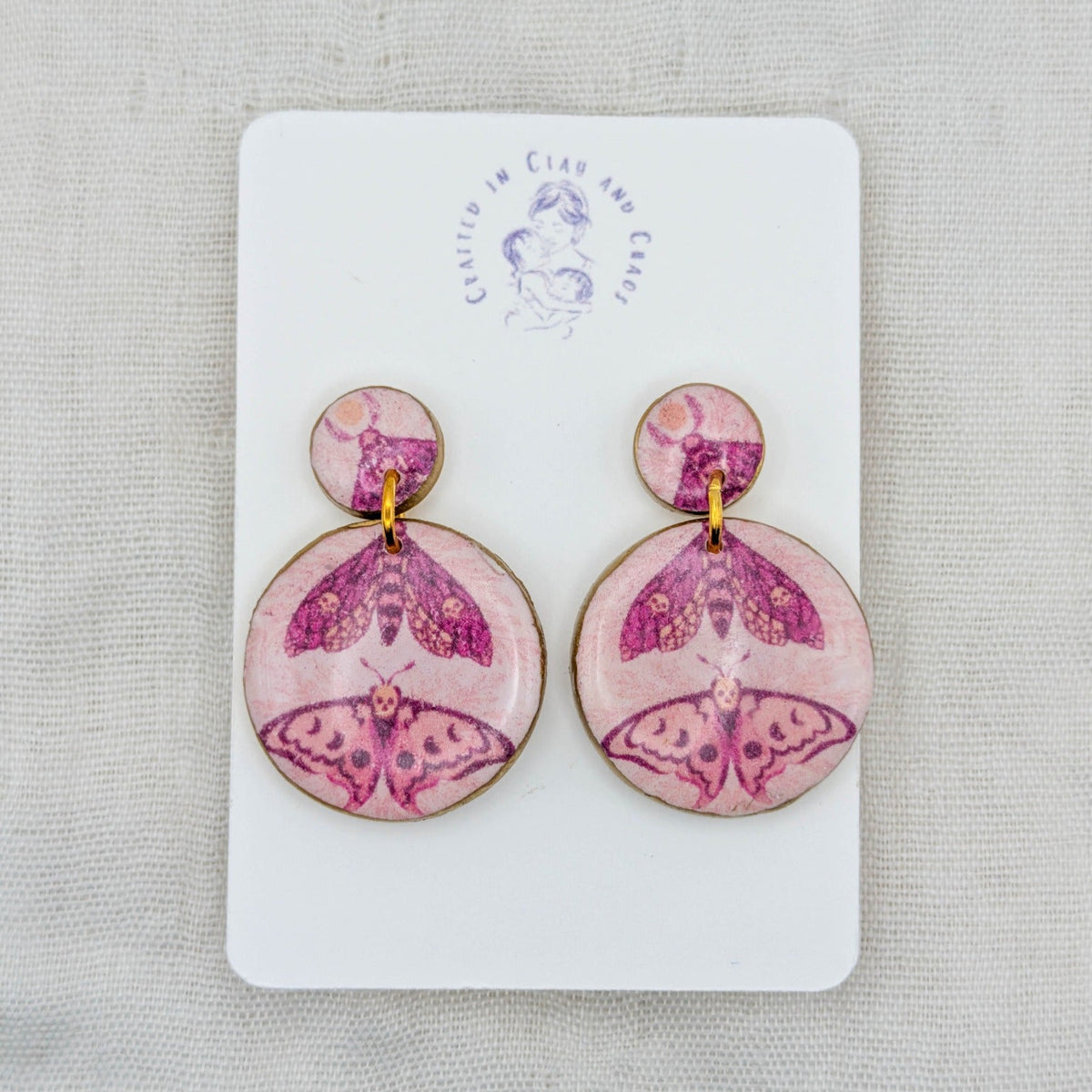 Pink and gold circle moth earrings in a pastel goth fairycore style