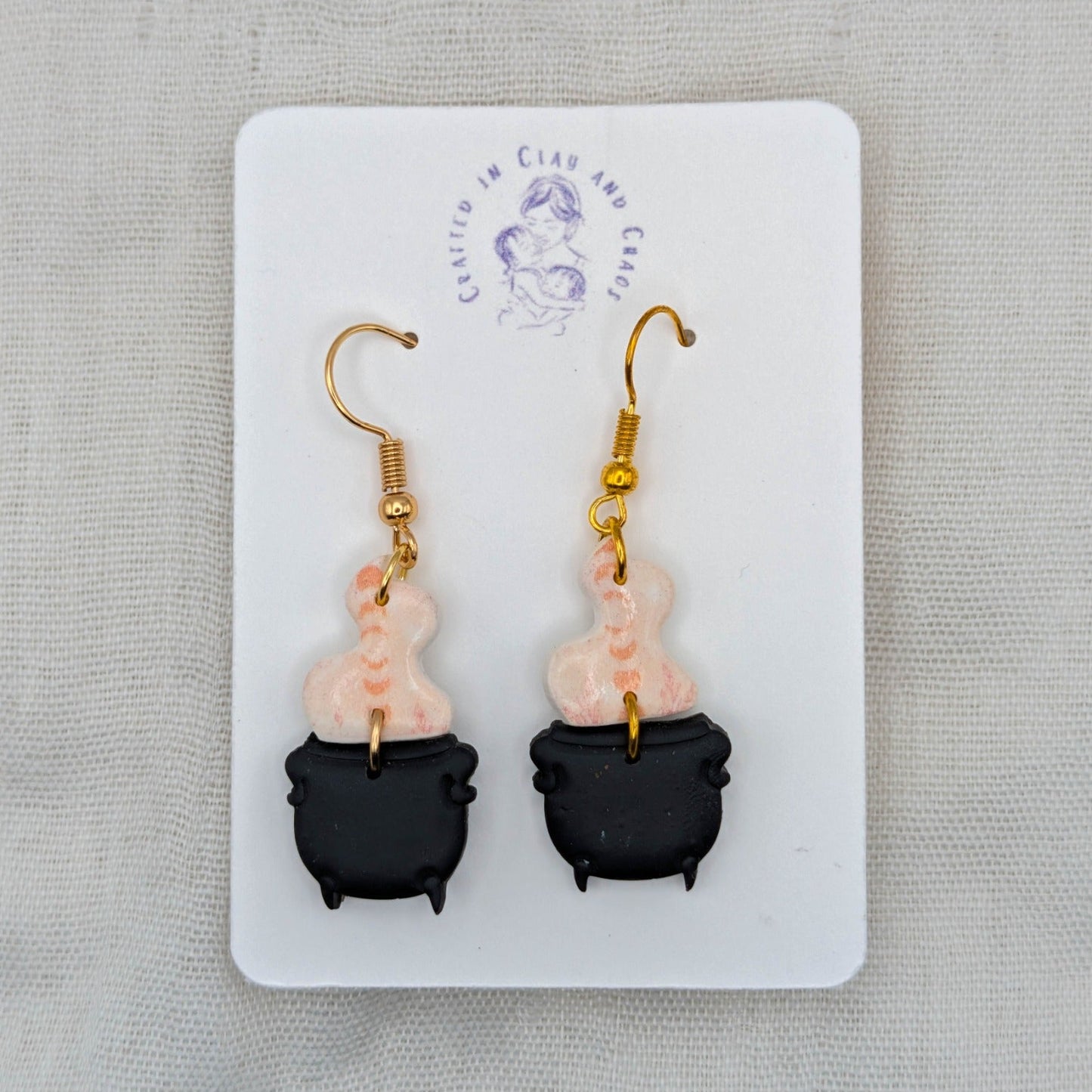 Pale pink marbled potion smoke earrings with black cauldrons and 18K gold-plated stainless steel hooks