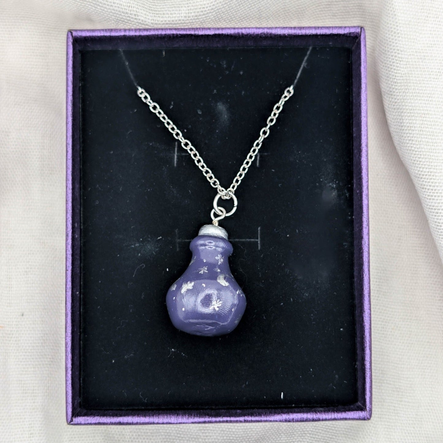 Handmade purple 3D potion bottle necklace with silver celestial designs and stainless steel chain