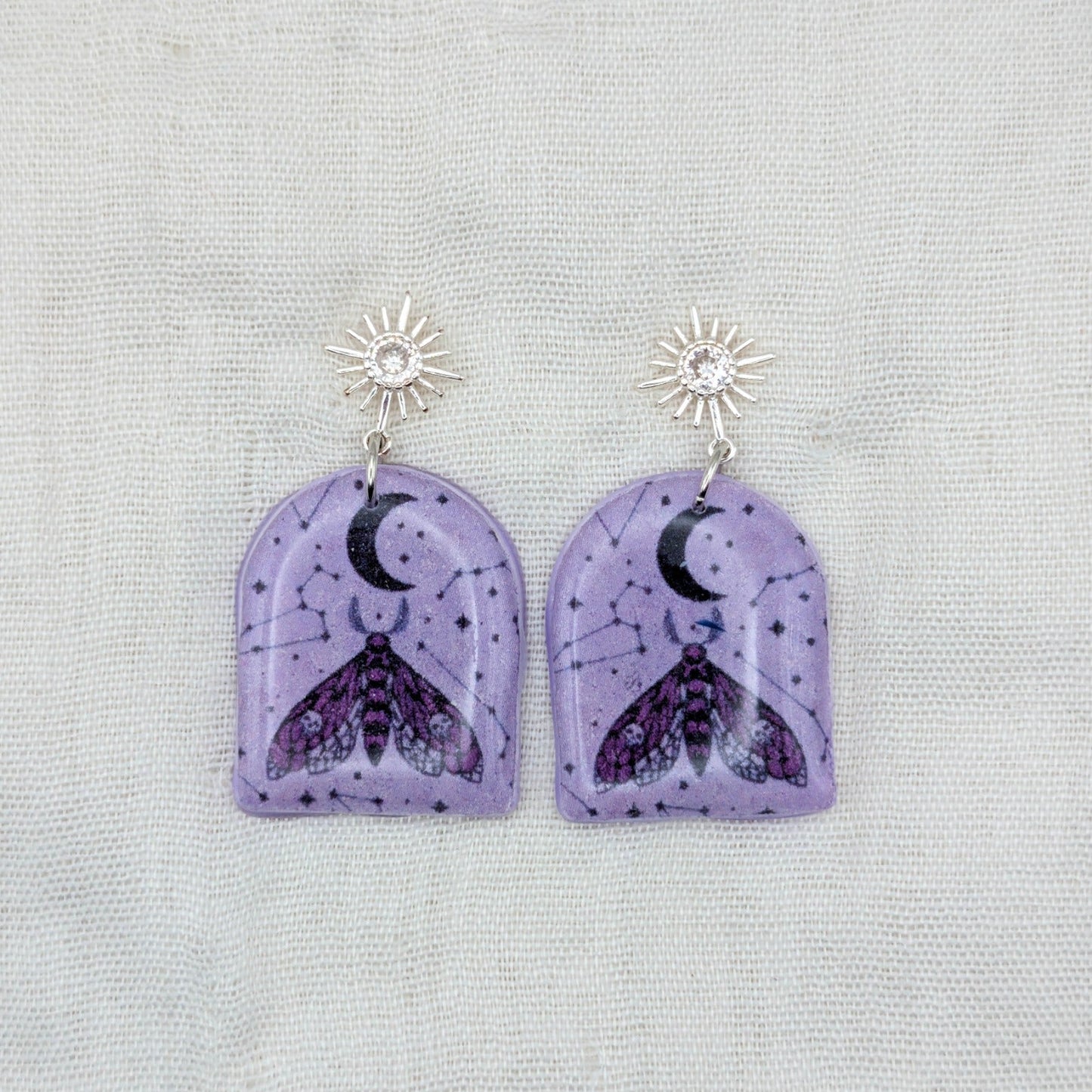 Purple moth arch earrings with silver cubic zirconia starburst posts and celestial pattern