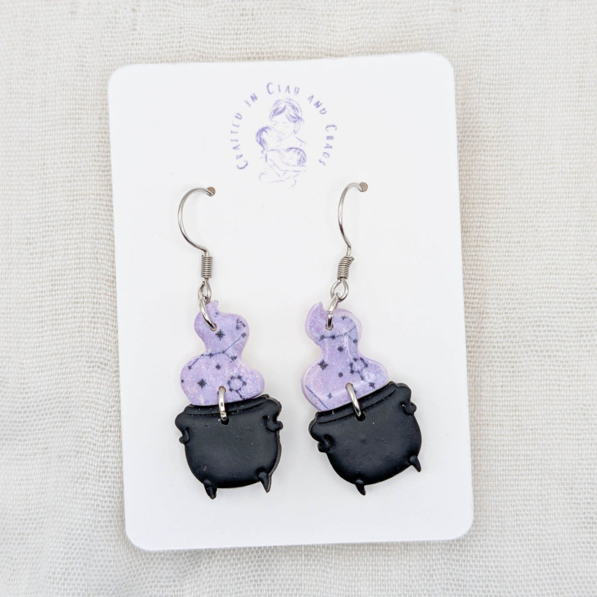 Light purple celestial potion smoke earrings with black cauldrons and surgical-grade stainless steel hooks