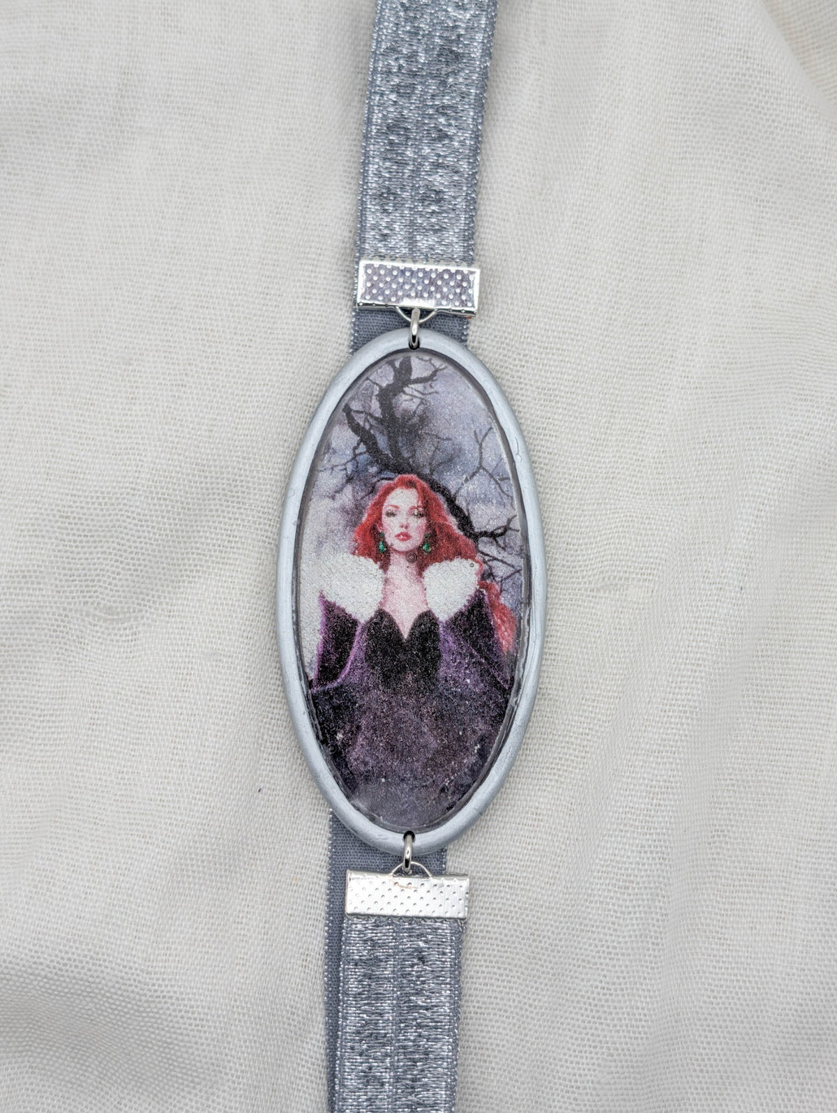 Silver framed polymer clay wrap-around bookmark with a red-haired gothic woman and silver elastic band