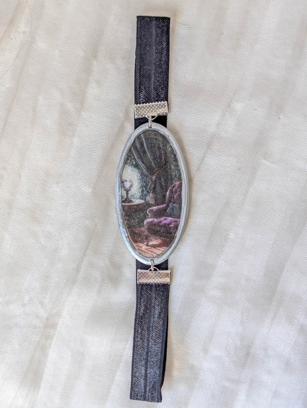 Full view of silver gothic reading chair polymer clay bookmark with black stretchy band