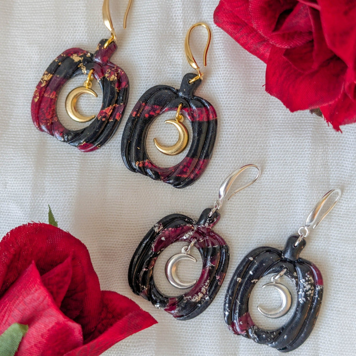 Crimson and black vampire marble pumpkin earrings with gold and silver crescent moon charms styled with red roses