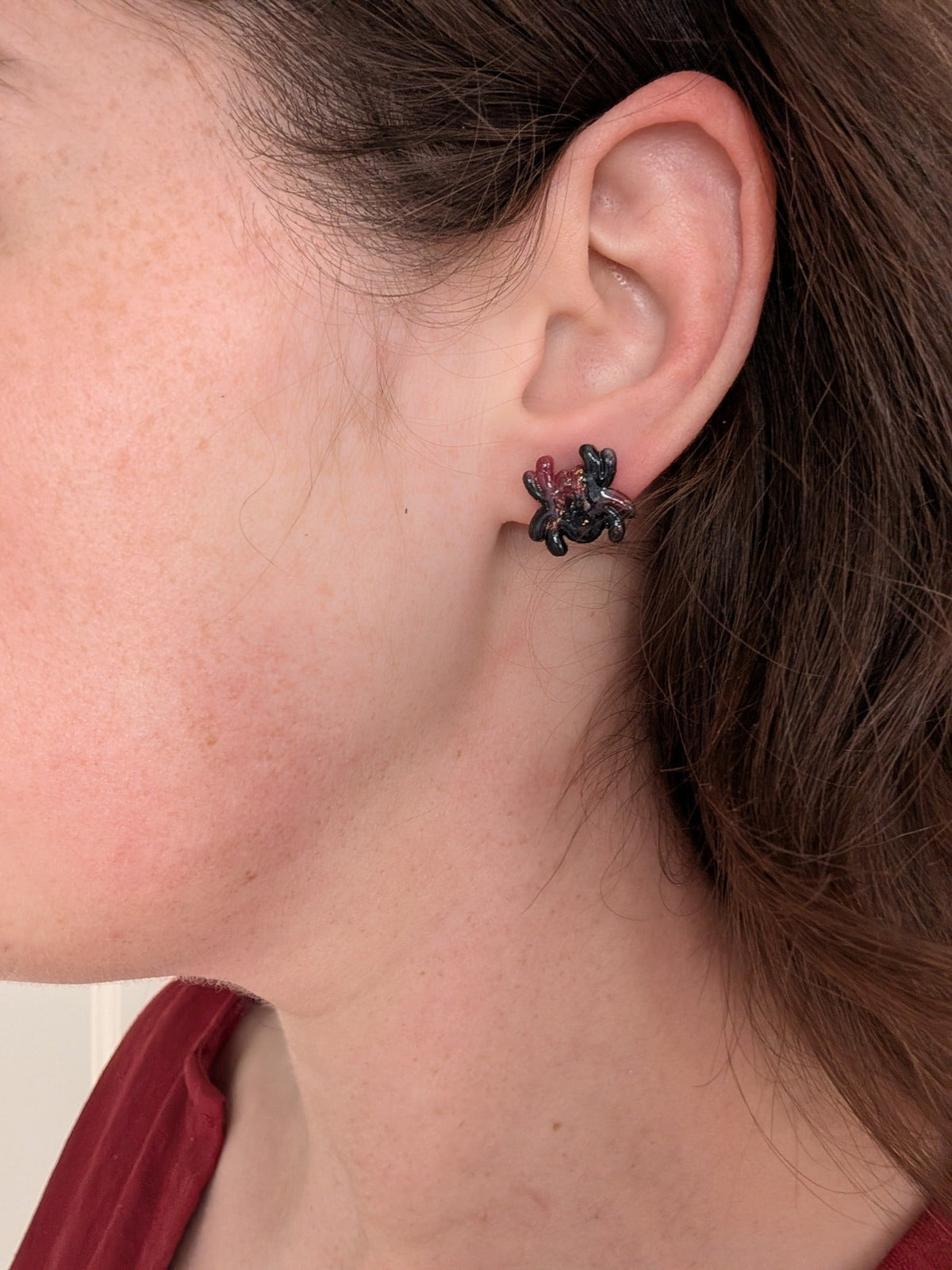 Crimson and black vampire marble spider stud earring worn on ear