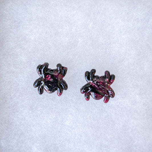 Crimson and black marbled spider stud earrings with a glossy finish