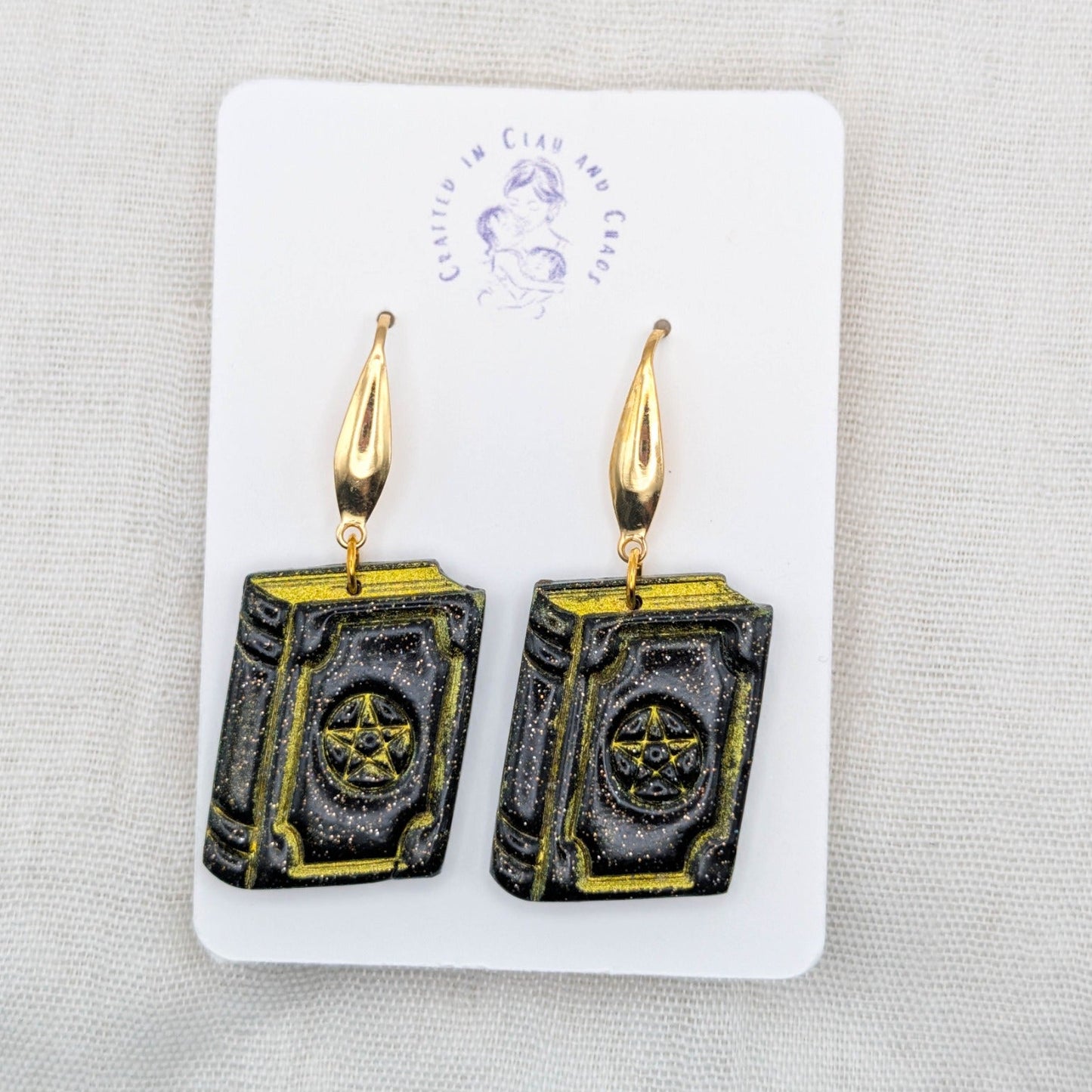 Handmade black shimmer witchy spellbook earrings with gold hooks